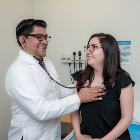 Médico cardiólogo auscultando una paciente Rehabilitación Cardíaca